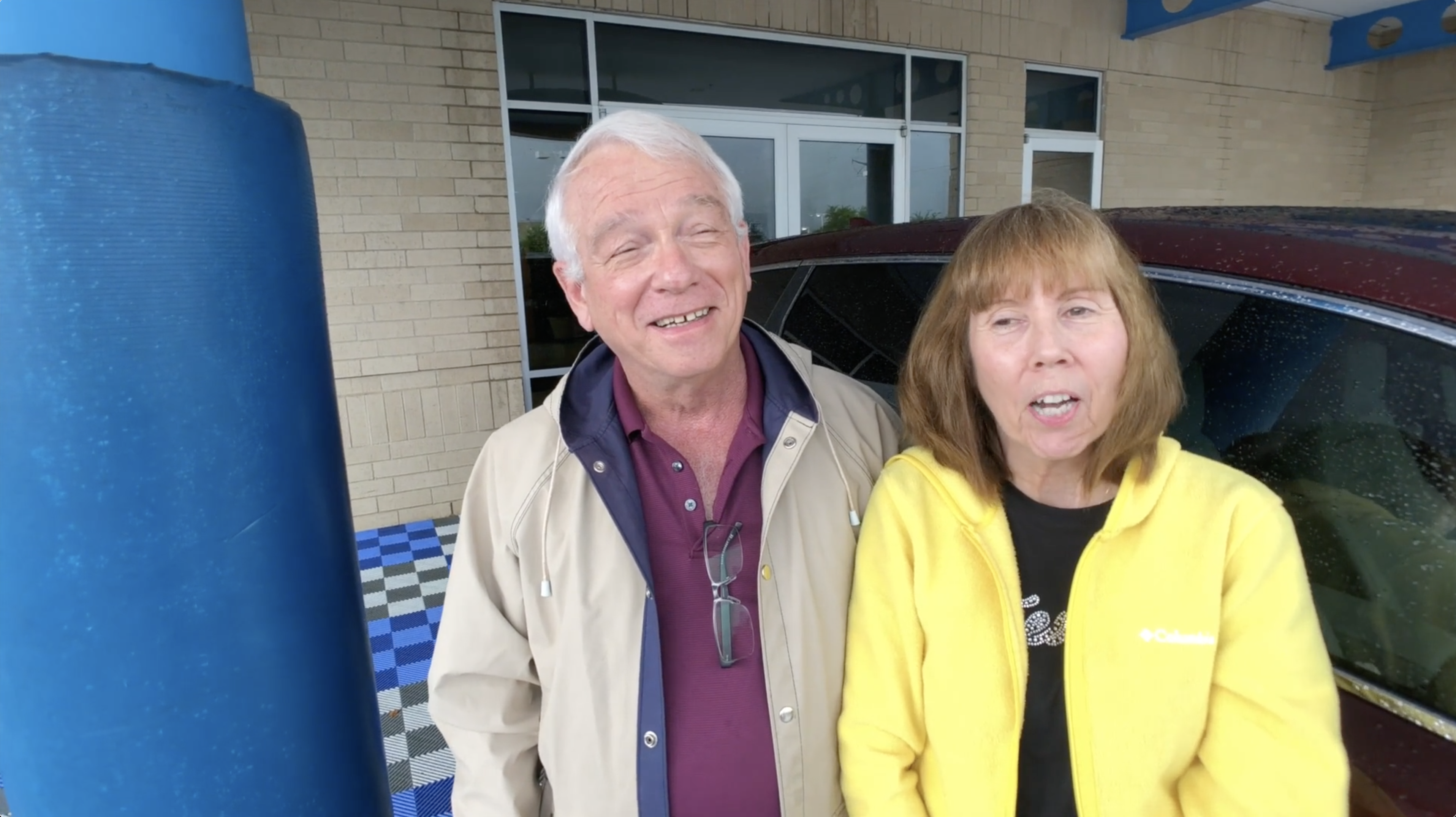 Two customers speaking outside a dealership